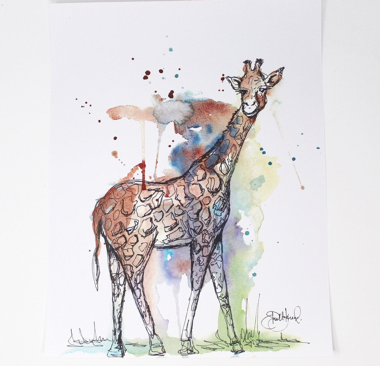 The Mixed Media Giraffe Art Print - 11x14in offers a captivating watercolor illustration of a giraffe set against a backdrop of blue, green, and brown splashes, making it a delightful addition to any nursery decor.