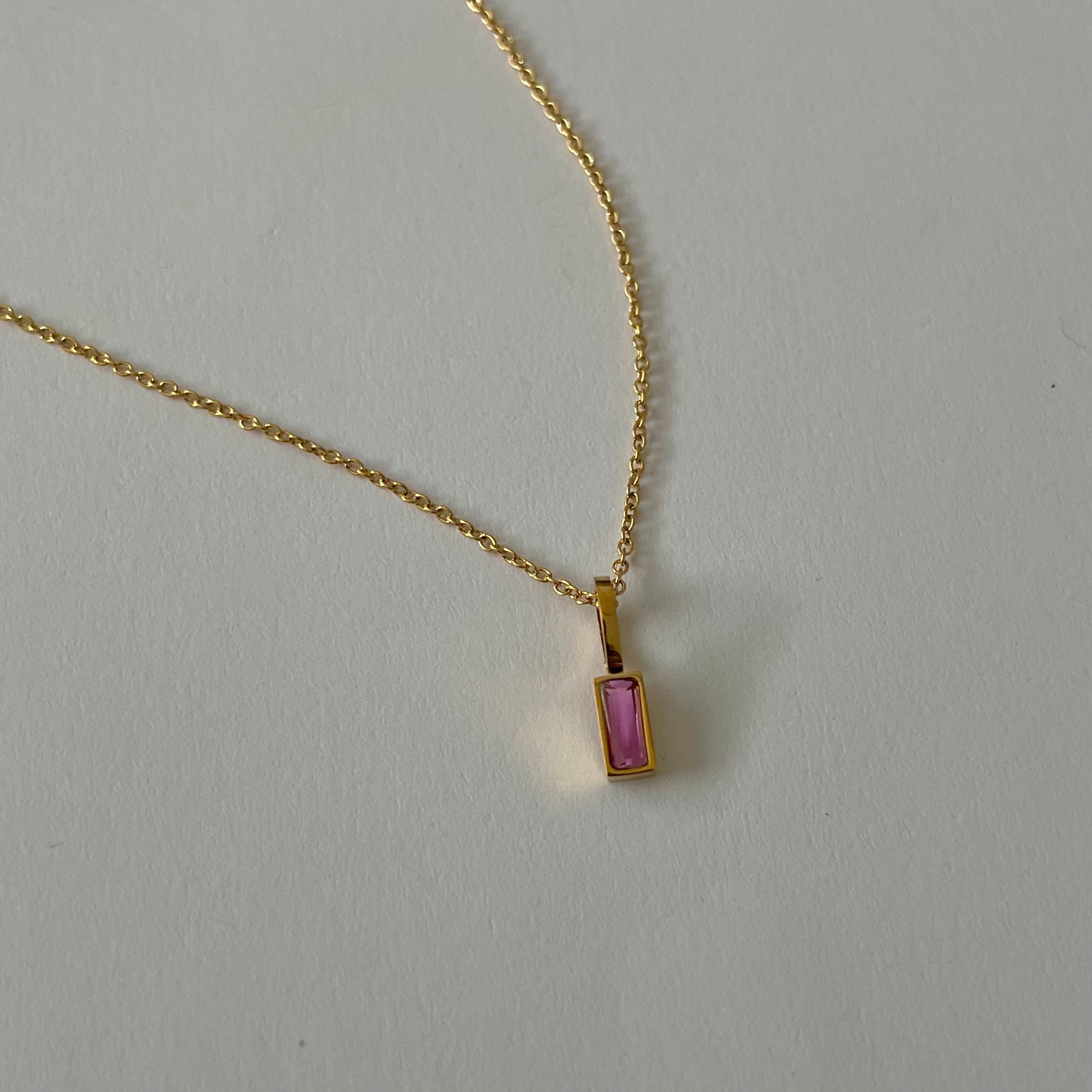 Birthstone necklaces, each featuring a rectangular gemstone pendant and thoughtfully handcrafted in Canada, are arranged neatly on a light surface.