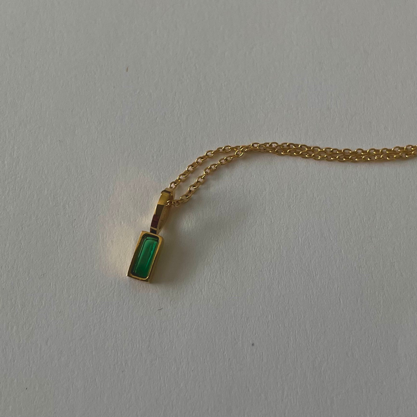 Birthstone necklaces, each featuring a rectangular gemstone pendant and thoughtfully handcrafted in Canada, are arranged neatly on a light surface.