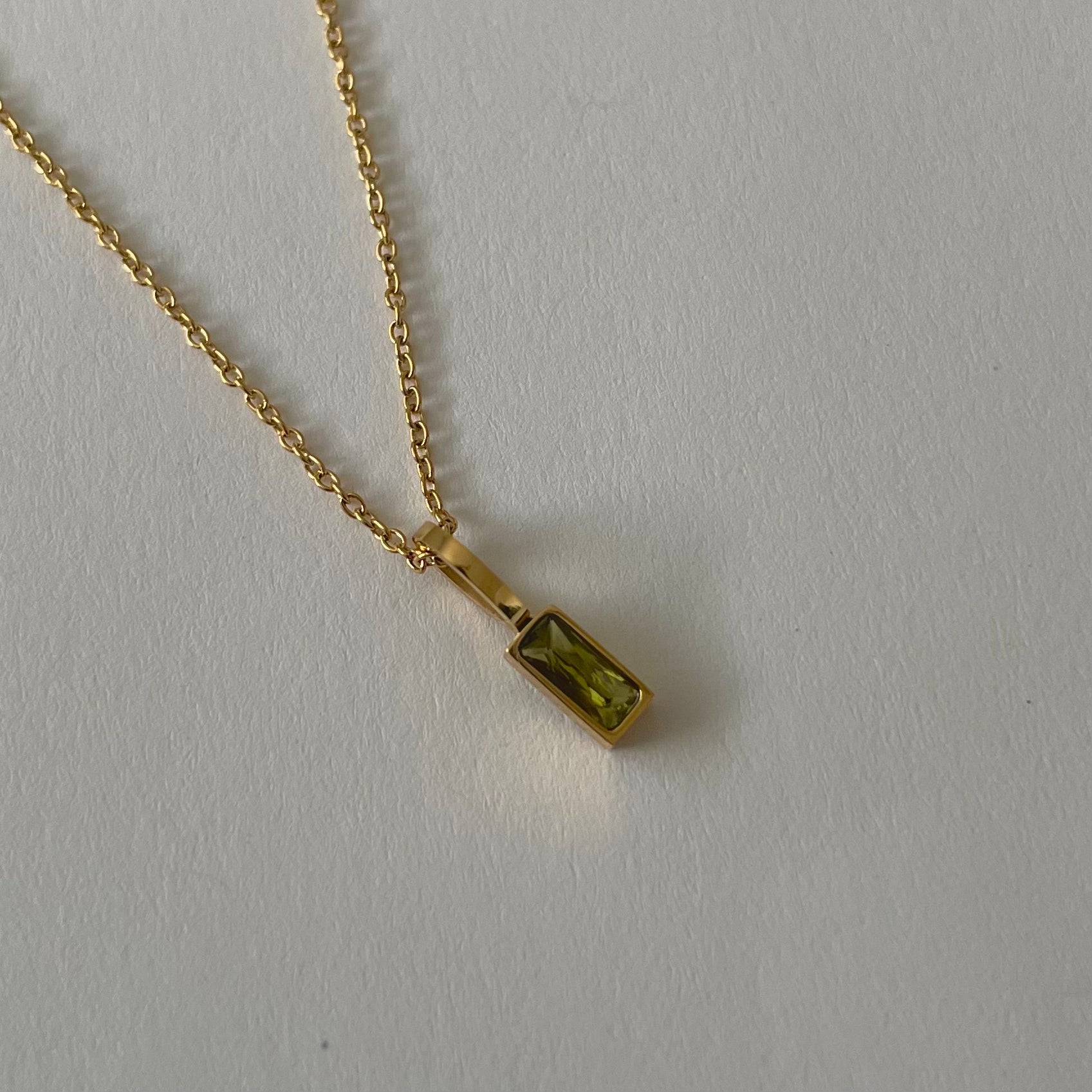 Birthstone necklaces, each featuring a rectangular gemstone pendant and thoughtfully handcrafted in Canada, are arranged neatly on a light surface.