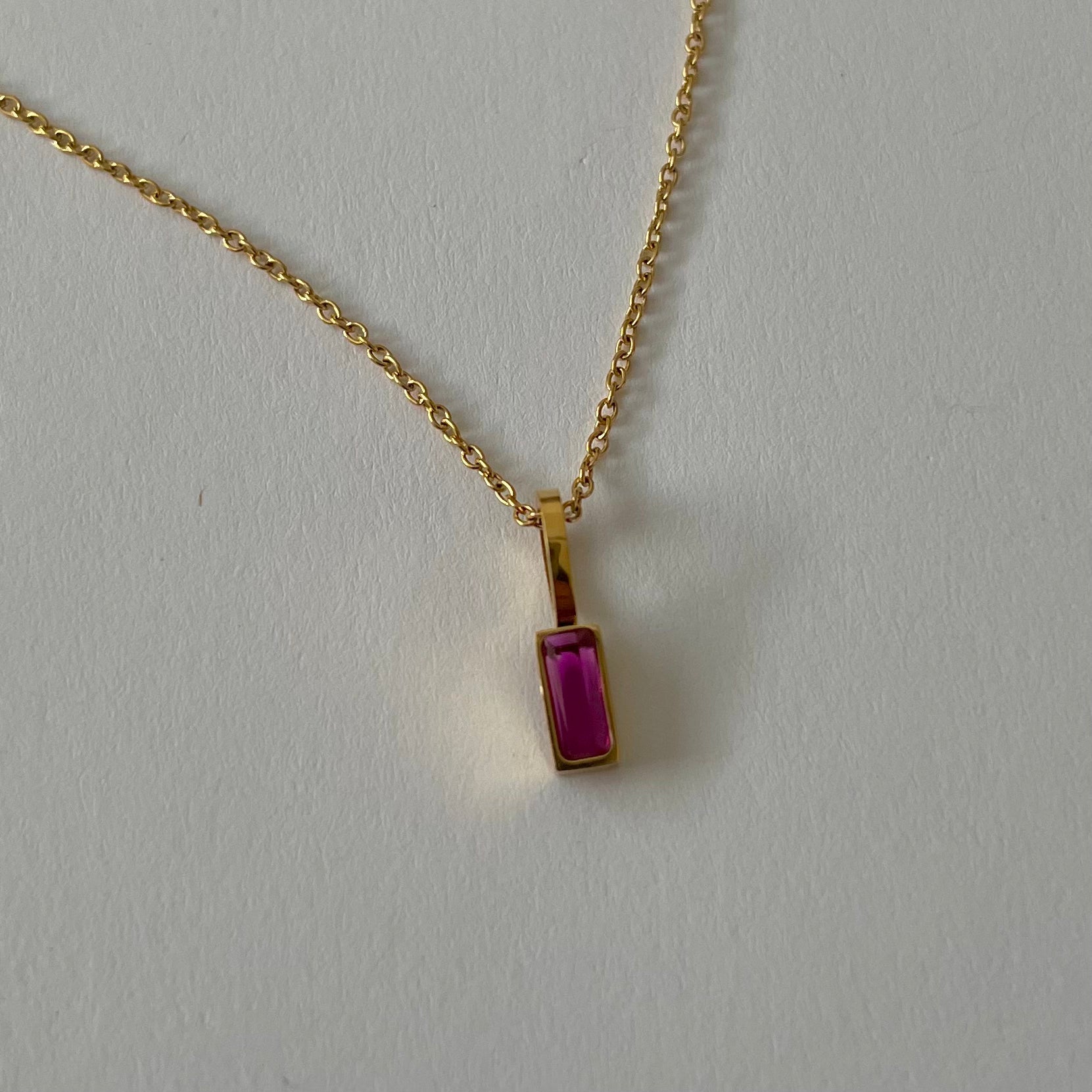 Birthstone necklaces, each featuring a rectangular gemstone pendant and thoughtfully handcrafted in Canada, are arranged neatly on a light surface.