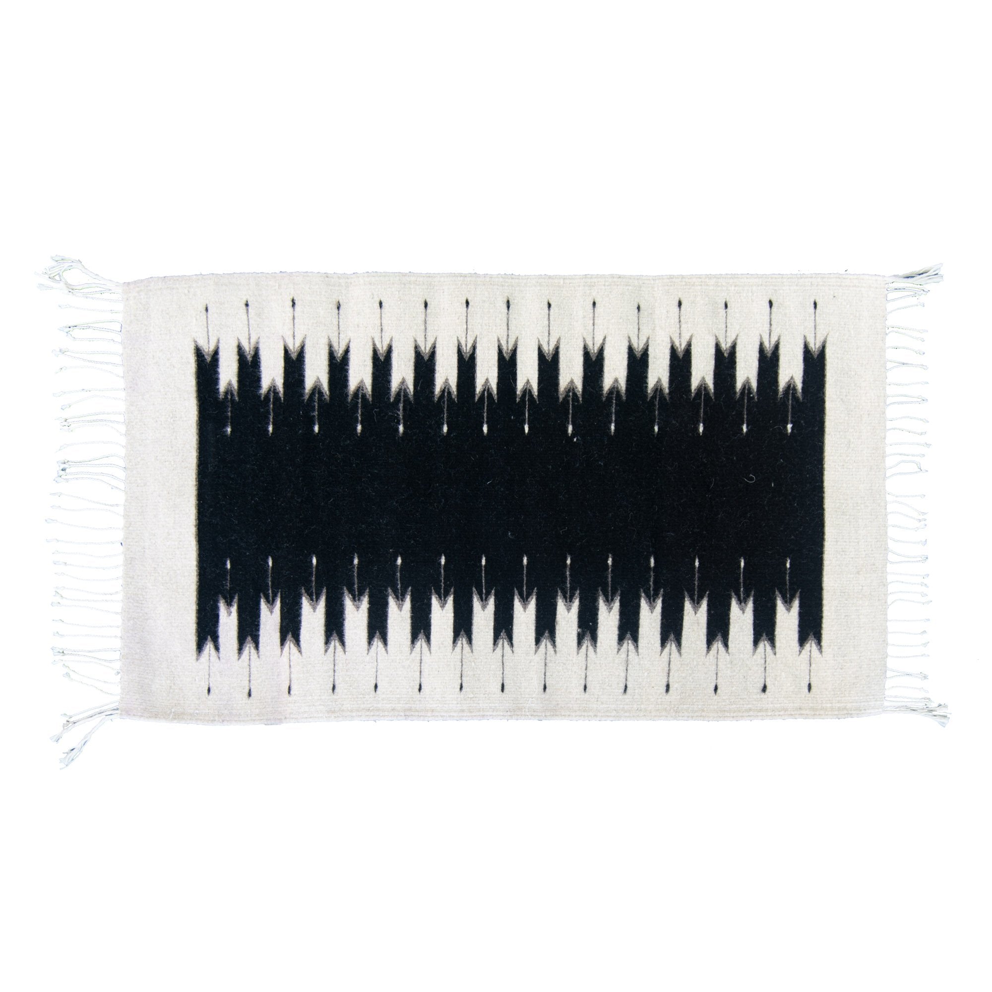 A mid-century modern leather armchair beside a white brick fireplace, with a Beleroó Handmade Southwestern Style Rug. Lightling Pattern in front and a metal watering can on the side.