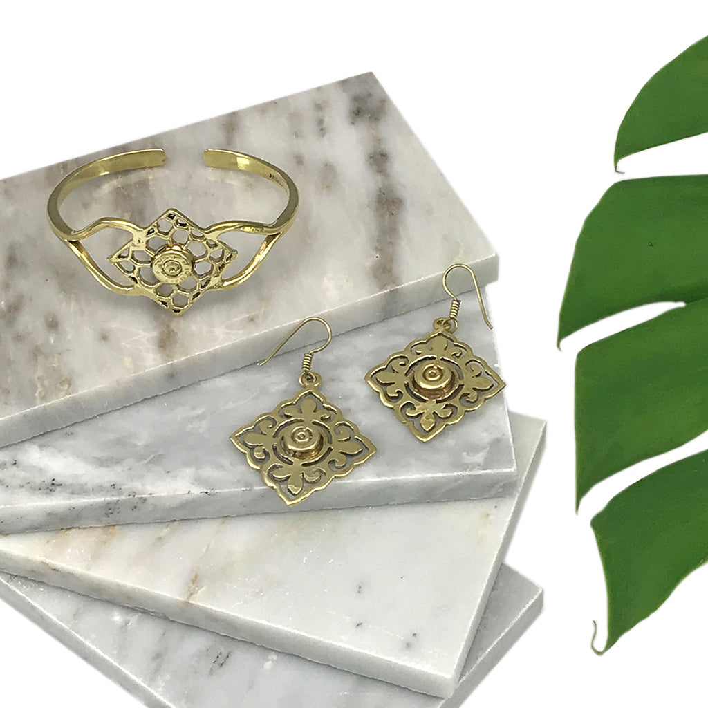 The Angkor Bullet Cuff is a stunning gold cuff bracelet that showcases an intricate openwork floral design, handcrafted with artisan craftsmanship. Made in Cambodia, this unique piece elegantly combines history and artistry by using recycled bombshell jewelry.