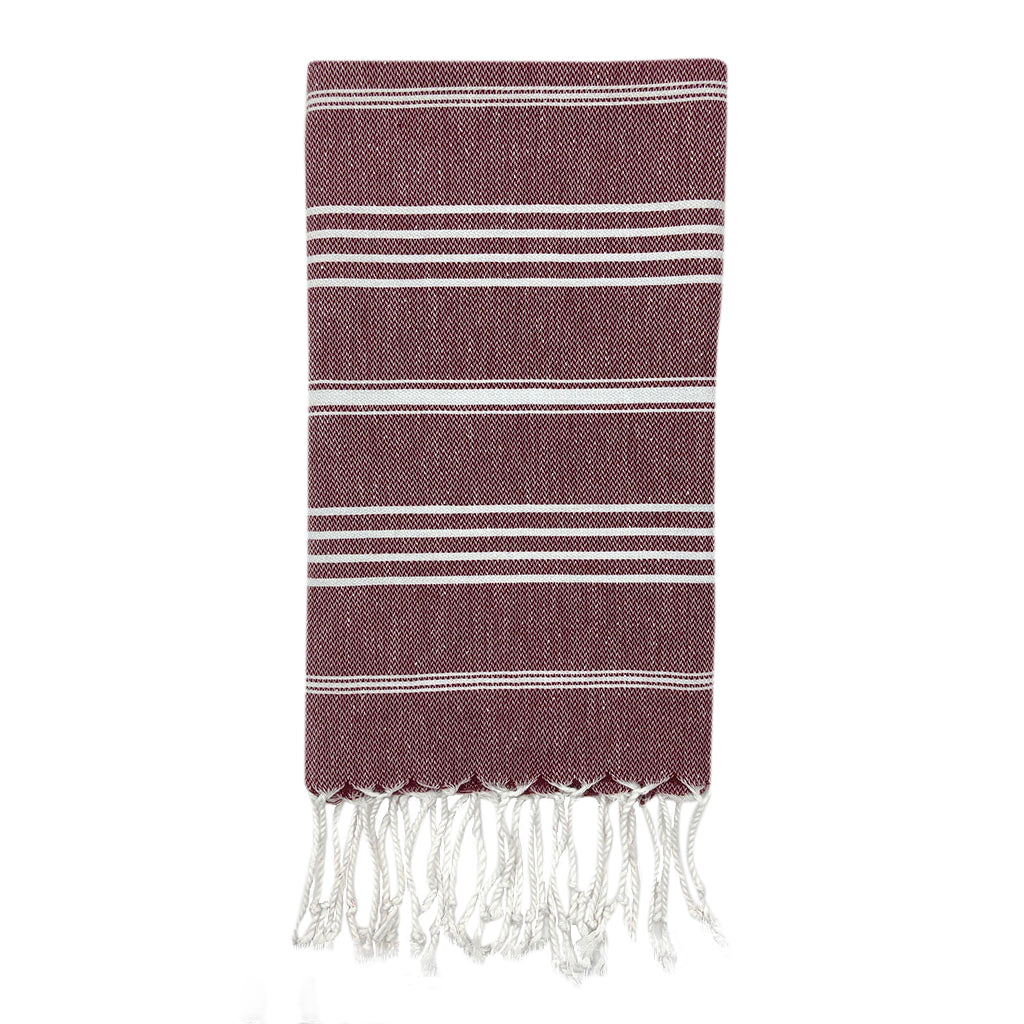The Classic Turkish Hand Towels in five elegant striped designs, featuring shades of blue, brown, beige, navy, and grey, are beautifully displayed. Made from 100% Turkish cotton and adorned with white fringe on one end, they offer exceptional absorbency for all your needs.