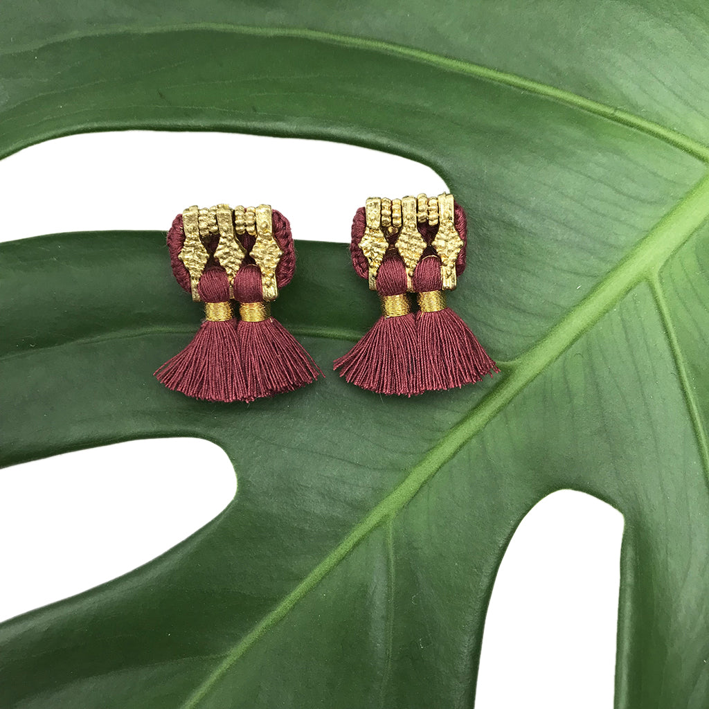 A pair of Jhumka Earrings in gold and black, showcasing detailed geometric designs with fringed ends.