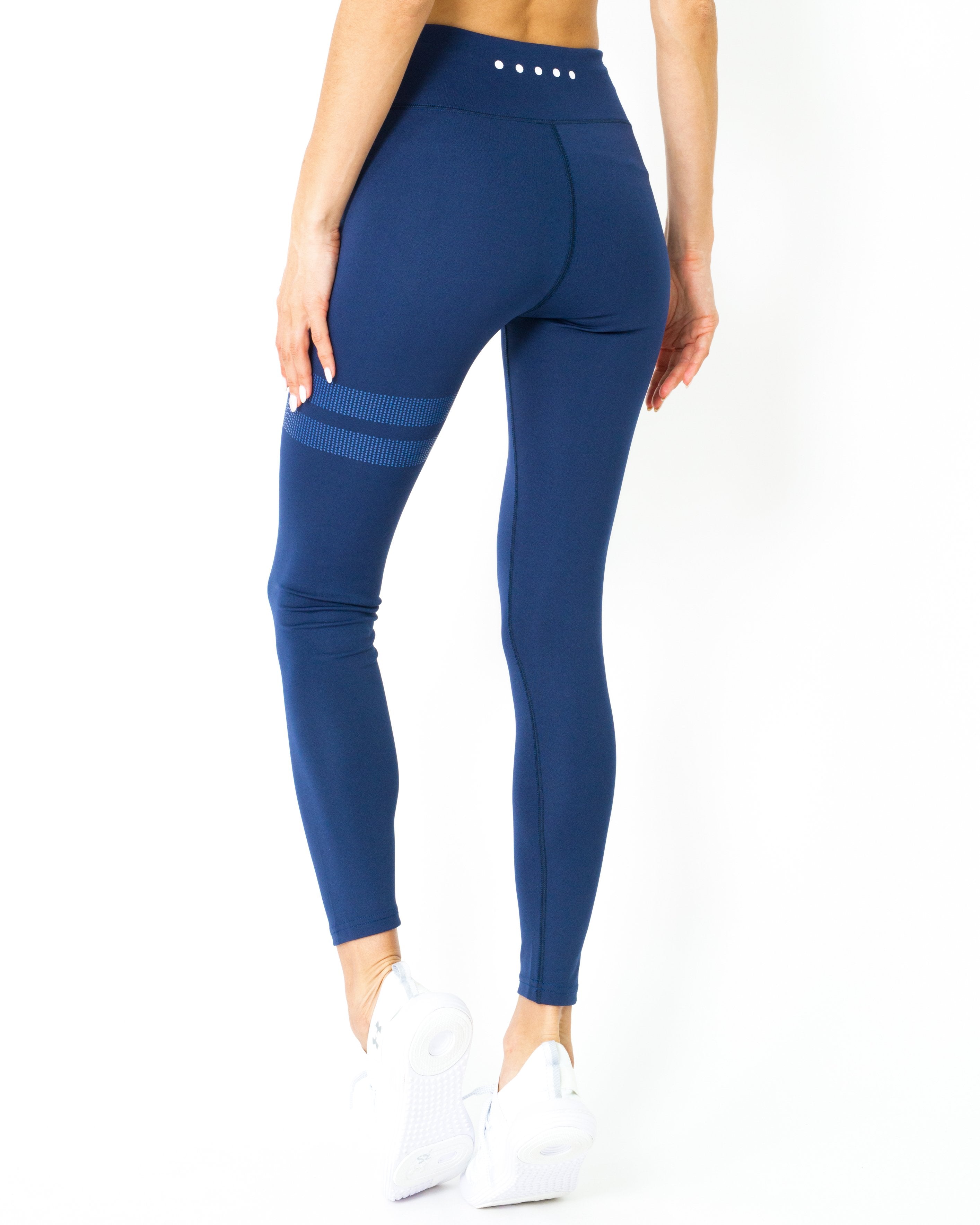 A person wearing navy blue Ashton Leggings from Savoy Active, made from Brazilian textile, showcases the sculpted compression fit in a side profile with one leg slightly forward.