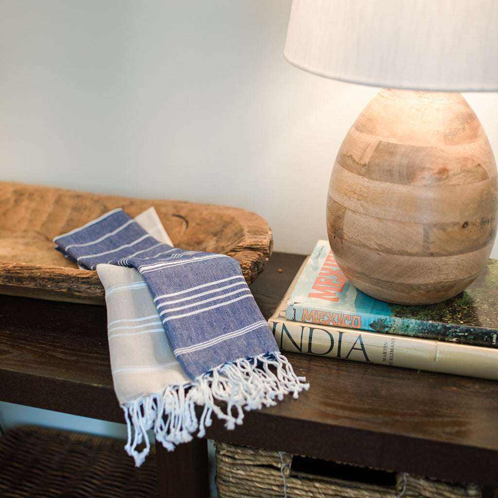 The Classic Turkish Hand Towels in five elegant striped designs, featuring shades of blue, brown, beige, navy, and grey, are beautifully displayed. Made from 100% Turkish cotton and adorned with white fringe on one end, they offer exceptional absorbency for all your needs.