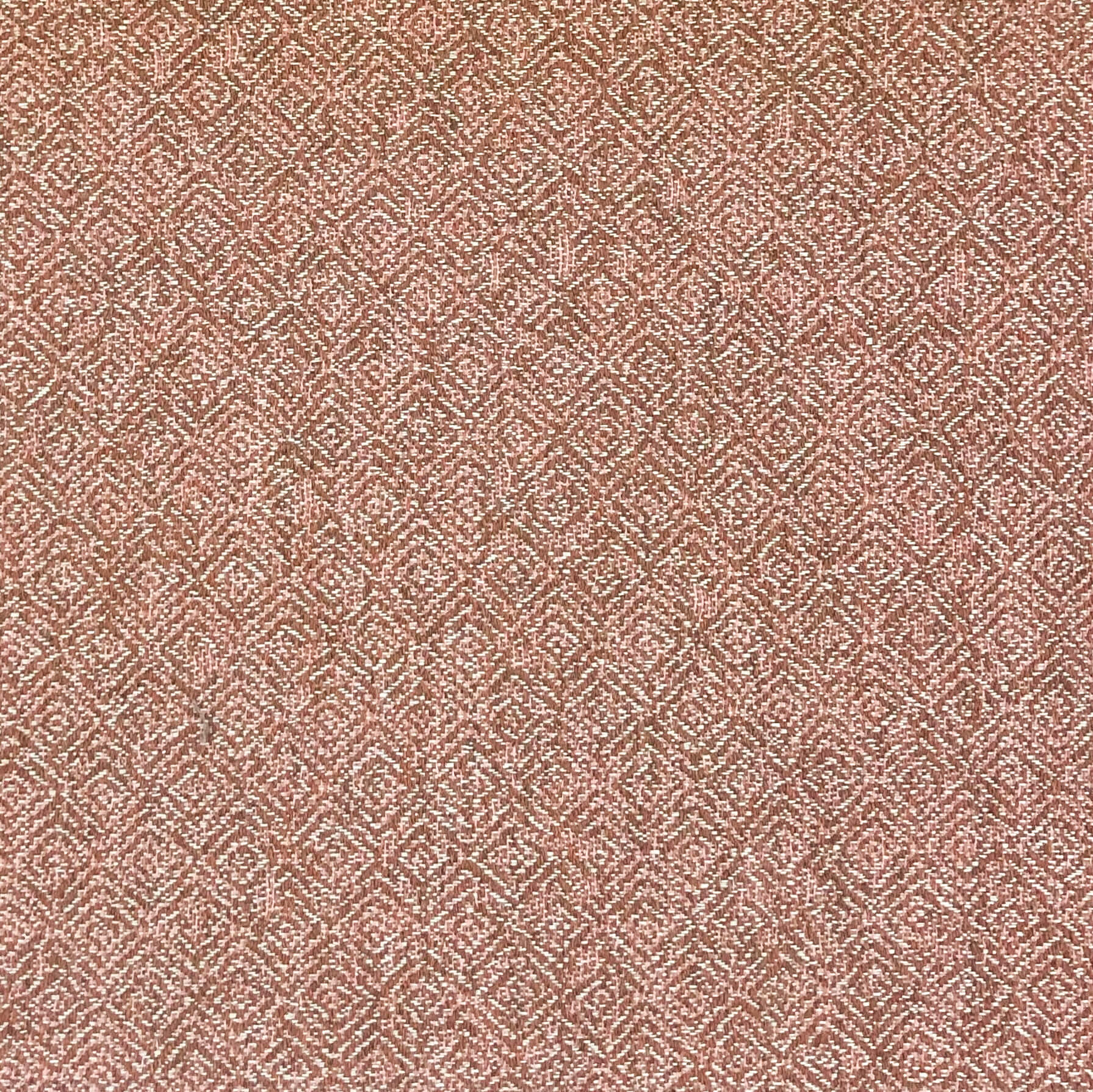 The Lounger Pet Bed in Pittie Pink features a textured surface with a repeating geometric pattern in shades of red and white, reminiscent of intricate woven or embroidered fabric, crafted from Sunbrella fabric made using recycled plastic water bottles.