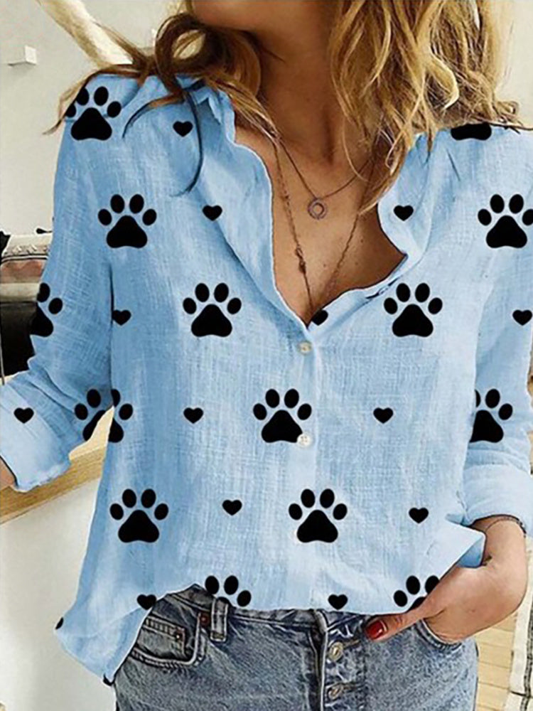 Woman in a Leisure White Yellow Shirts Button Lapel Cardigan Top with black paw print pattern details, unbuttoned at the collar, paired with jeans.