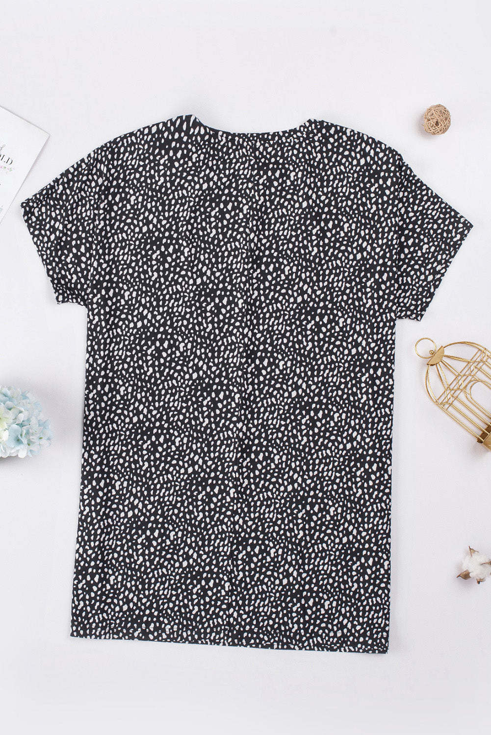 A woman wearing a black leopard print side pockets tunic top.