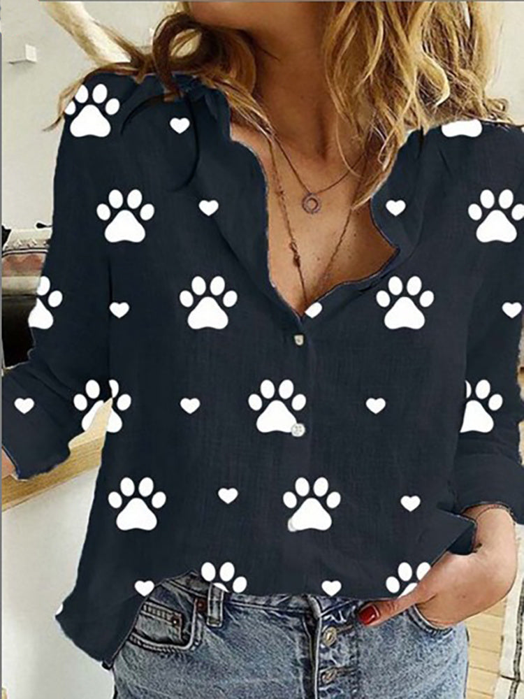 Woman in a Leisure White Yellow Shirts Button Lapel Cardigan Top with black paw print pattern details, unbuttoned at the collar, paired with jeans.