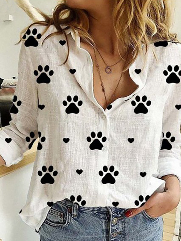 Woman in a Leisure White Yellow Shirts Button Lapel Cardigan Top with black paw print pattern details, unbuttoned at the collar, paired with jeans.