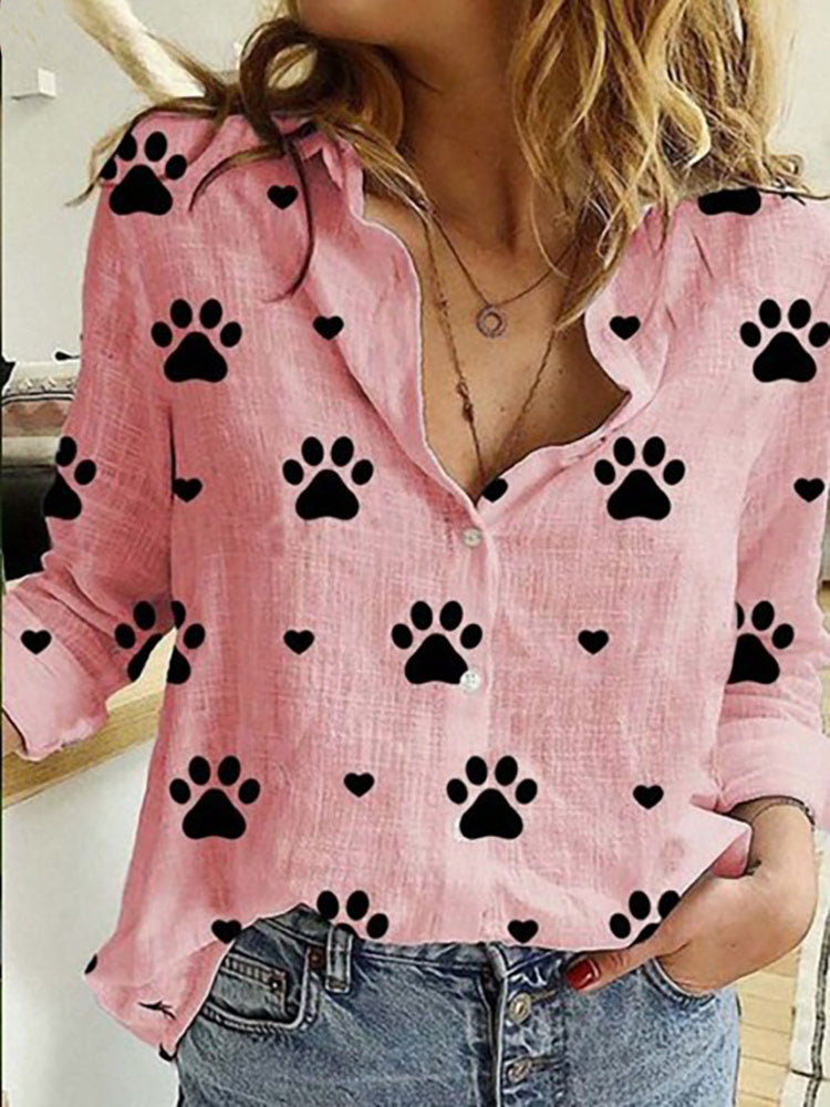 Woman in a Leisure White Yellow Shirts Button Lapel Cardigan Top with black paw print pattern details, unbuttoned at the collar, paired with jeans.
