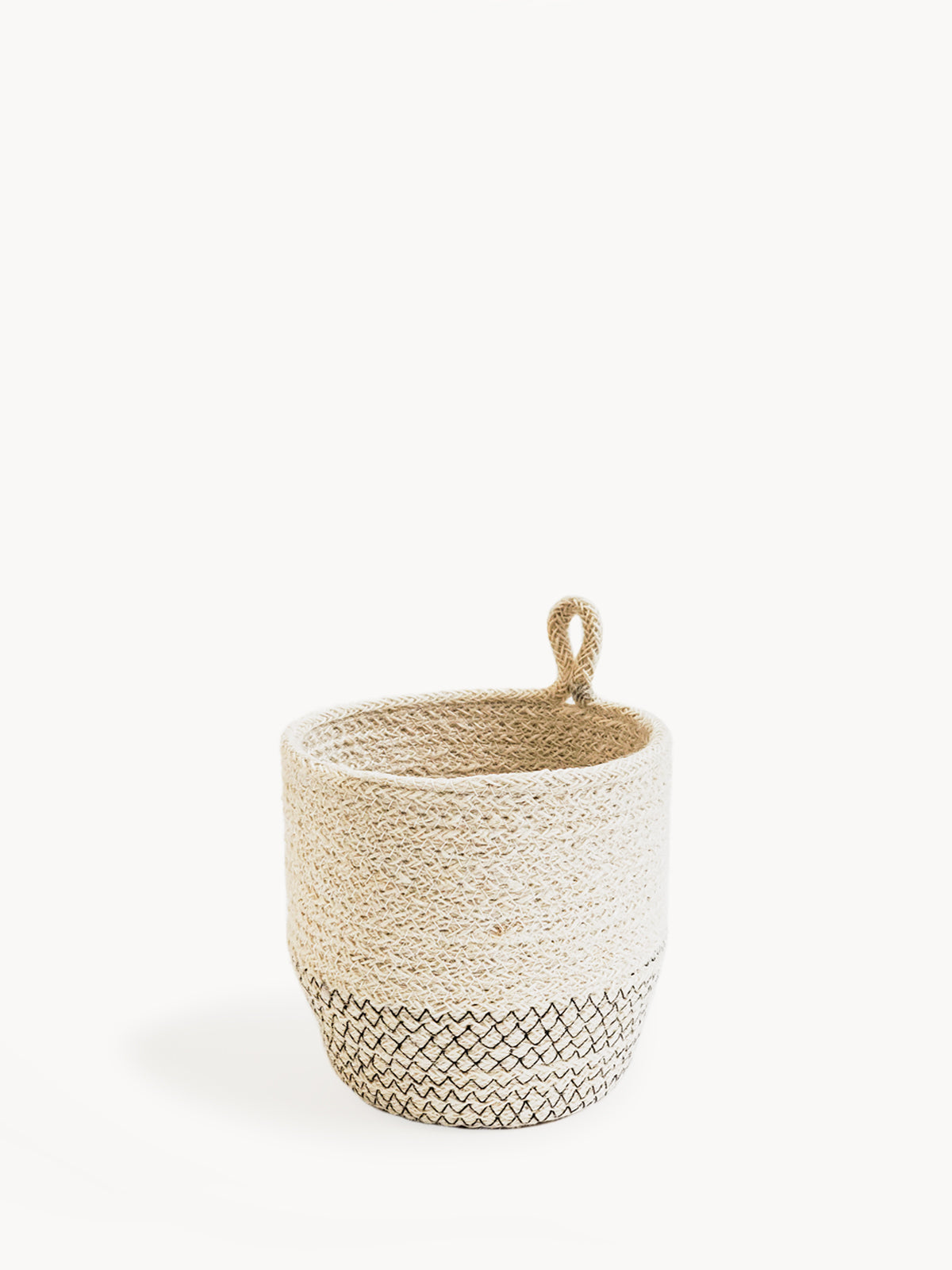 The Amari Loop Bin - Black, a beige and black woven basket featuring a loop handle, is elegantly displayed on a plain white background. Sustainably handmade by Fair Trade artisans, it seamlessly blends style with ethical craftsmanship.