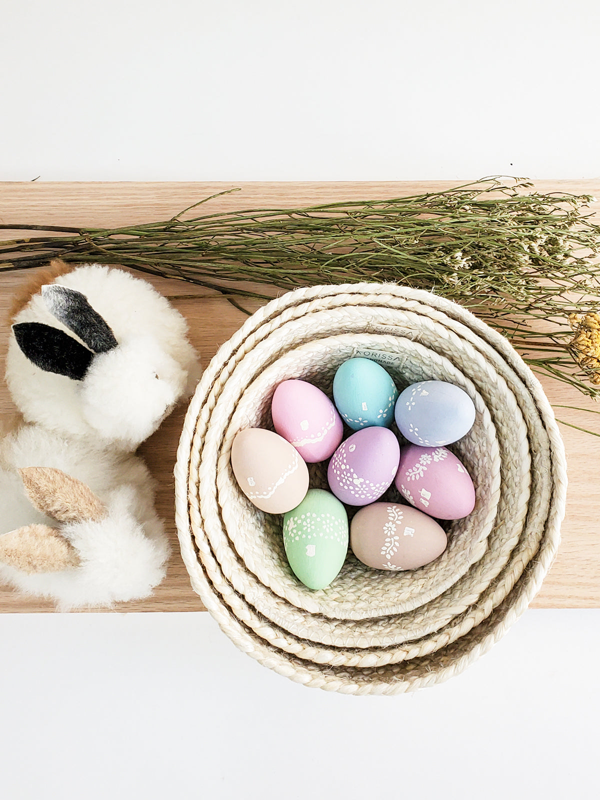 On a flat surface against a plain background, a set of four Kata Candy Bowls in white, crafted by fair trade artisans, is displayed. These versatile woven straw baskets highlight the beauty and authenticity of natural jute.