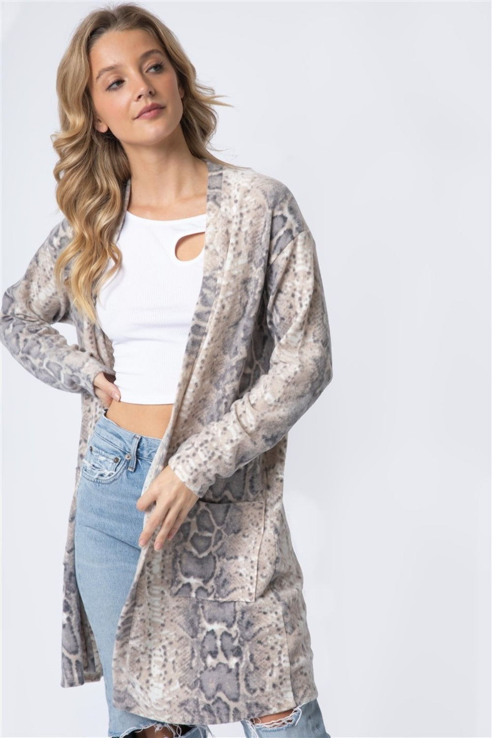 Person wearing a Cherish Apparel Animal Print Flannel Open Front Longline Cardigan with a snake motif, white top, and ripped jeans.