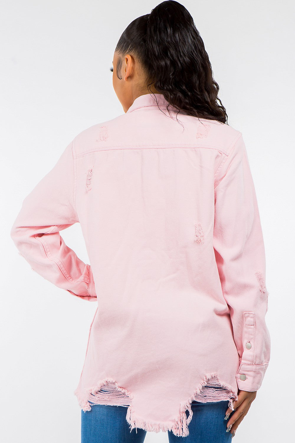 A person wearing the American Bazi Frayed Hem Distressed Denim Jacket in light pink, featuring silver buttons, is standing against a plain background, exuding a vintage look.