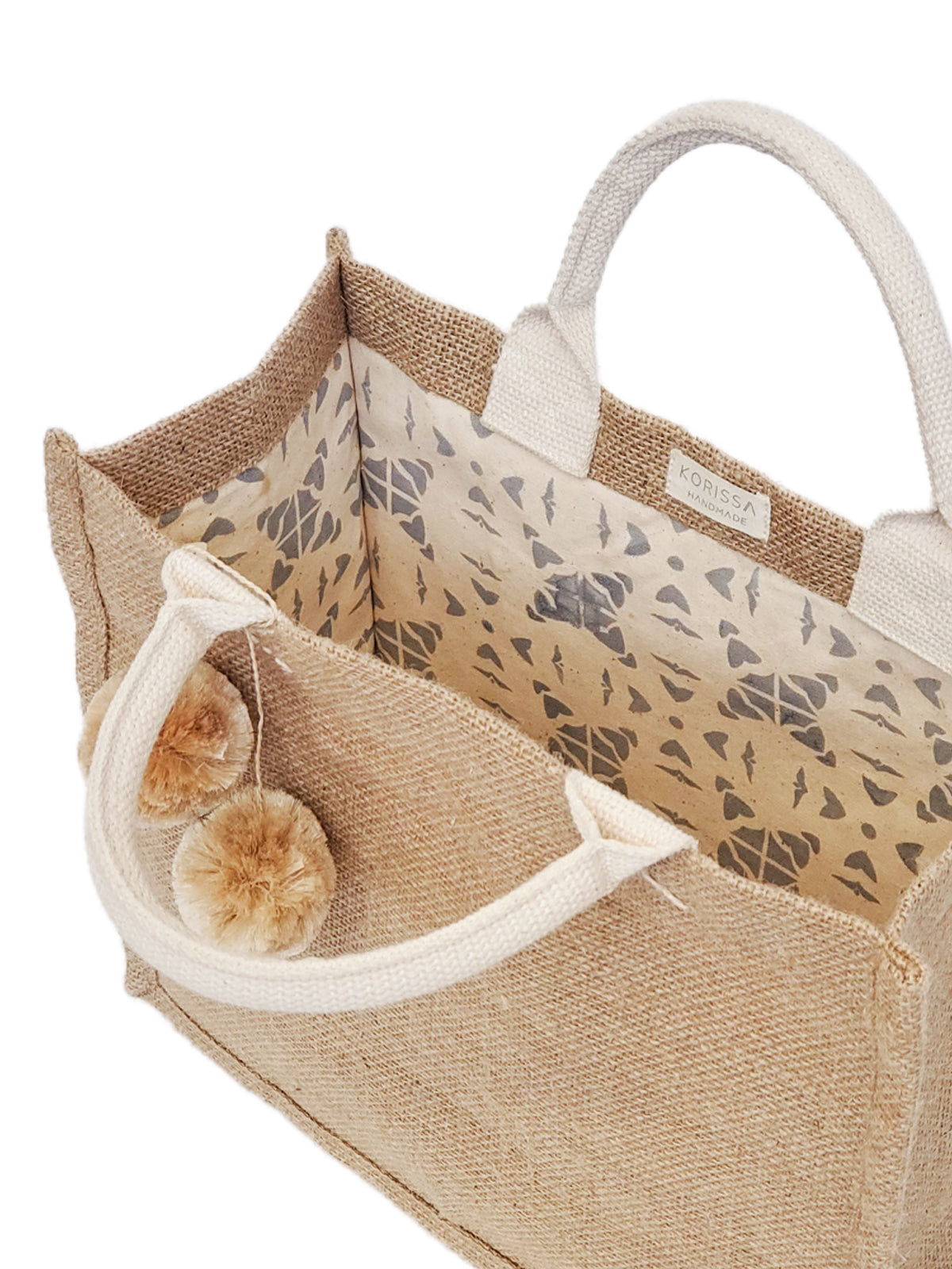 This Jute Canvas Gift Bag with Pompom, handcrafted with attention to detail, features white handles and two beige pom-poms, complemented by a charming patterned lining. Ideal for any fair trade enthusiast, it seamlessly blends style and ethics.