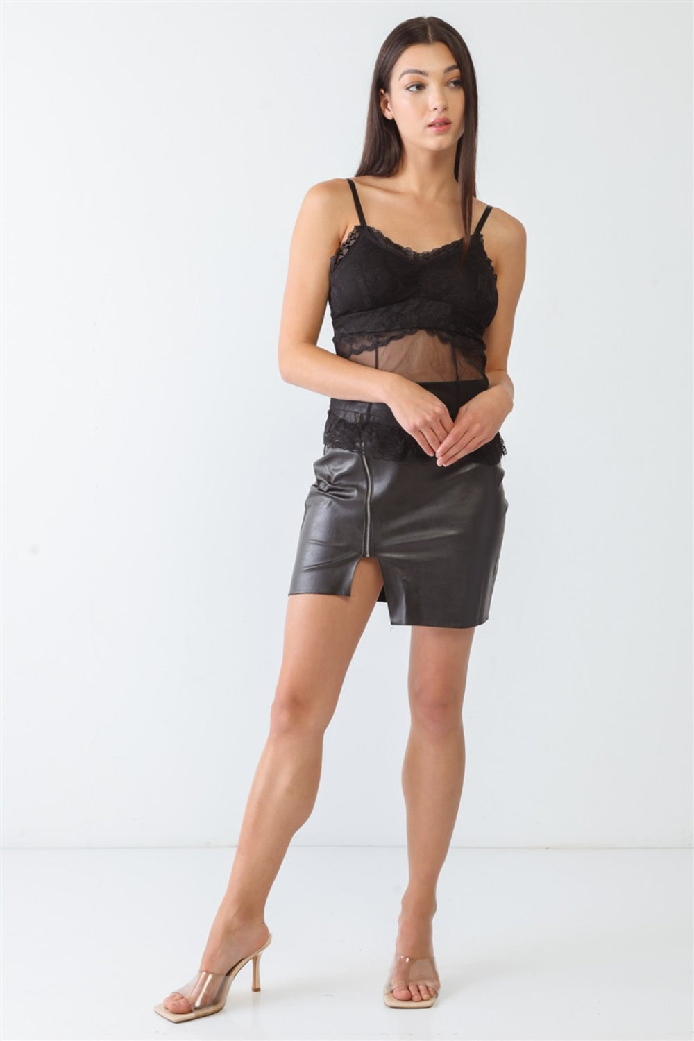 A woman stands wearing a FASHION4YOU Sheer Mesh Lace Push-Up Bustier and a black leather skirt with a front slit against a plain background.