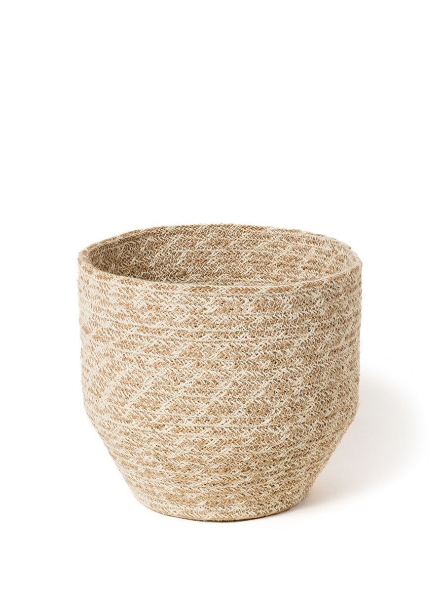 The Agora Bin set includes two woven baskets of different sizes, meticulously handmade from natural fibers. These exquisite pieces are adorned with jute yarn detailing and embody fair trade principles.