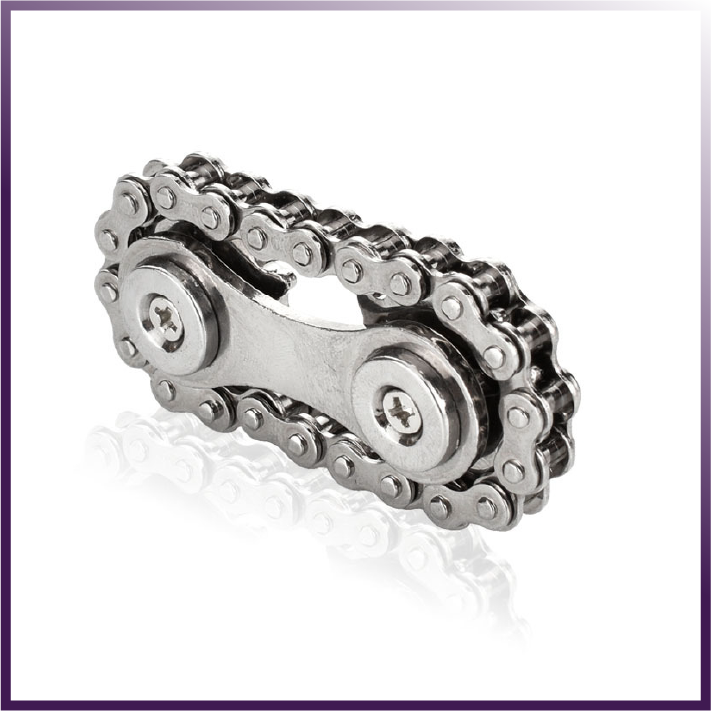 A Bike Chain Gear Spinner with two rivets lies on a glossy white surface, evoking the image of a sleek gear fidget spinner crafted for contemporary stress relief.