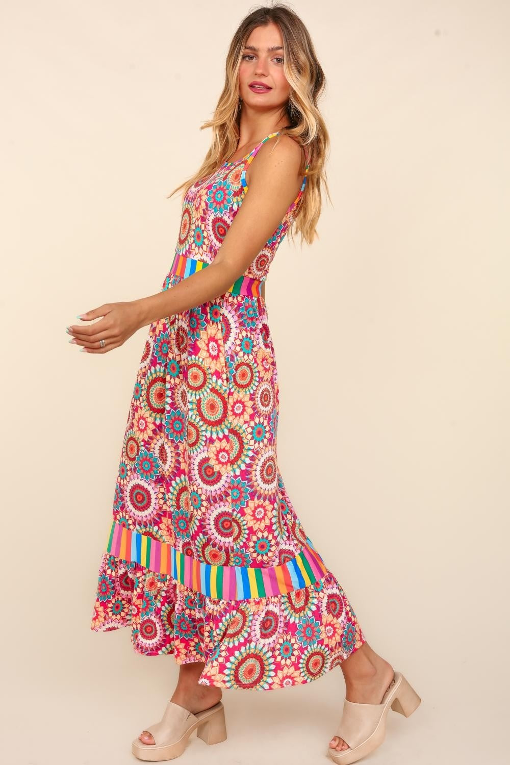 A woman in a vibrant Haptics Full Size Crochet Sleeveless Maxi Dress with side pockets stands and smiles against a plain background, ready for the summer soiree.