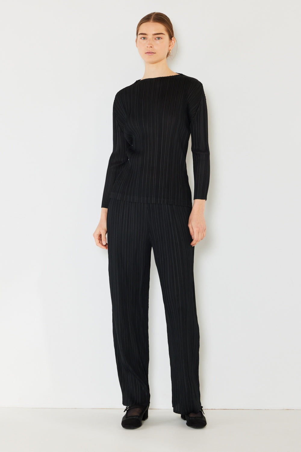 A person wearing the Marina West Swim Pleated Long Sleeve Boatneck Top with matching pants stands against a plain background.