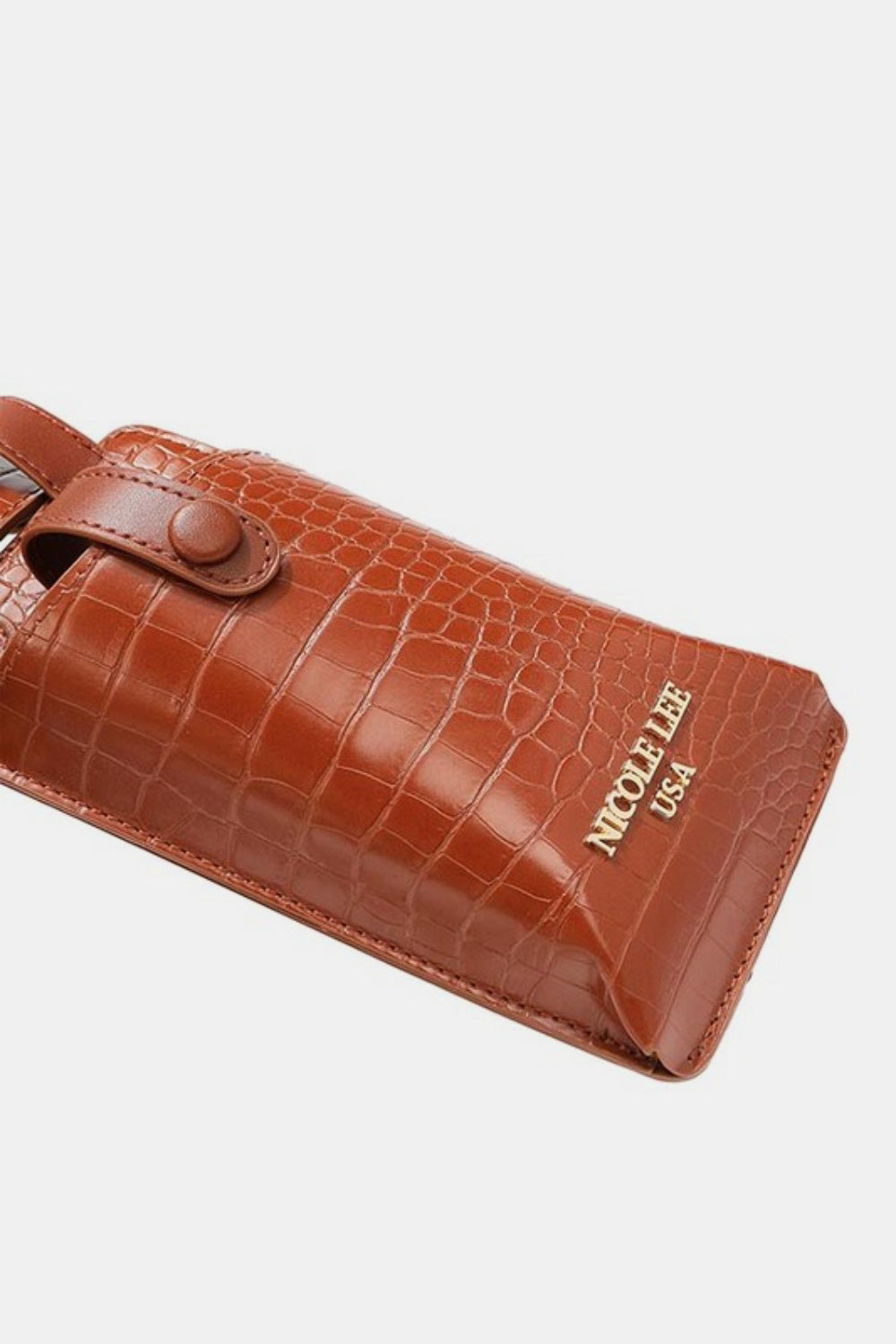 The Nicole Lee USA 2 Piece Texture Belt Bag is a brown vegan leather belt with an attached phone case and small pouch featuring a crocodile skin pattern. The adjustable belt also includes removable pouches for added convenience and style.