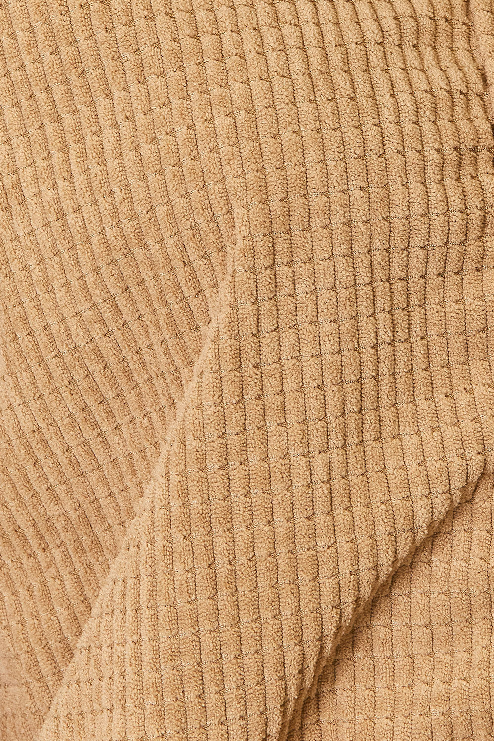 A person wearing the versatile Perfee Long Sleeve Dropped Shoulder Jacket in brown corduroy and blue jeans is standing indoors, smiling, with one hand resting on a white piece of furniture.