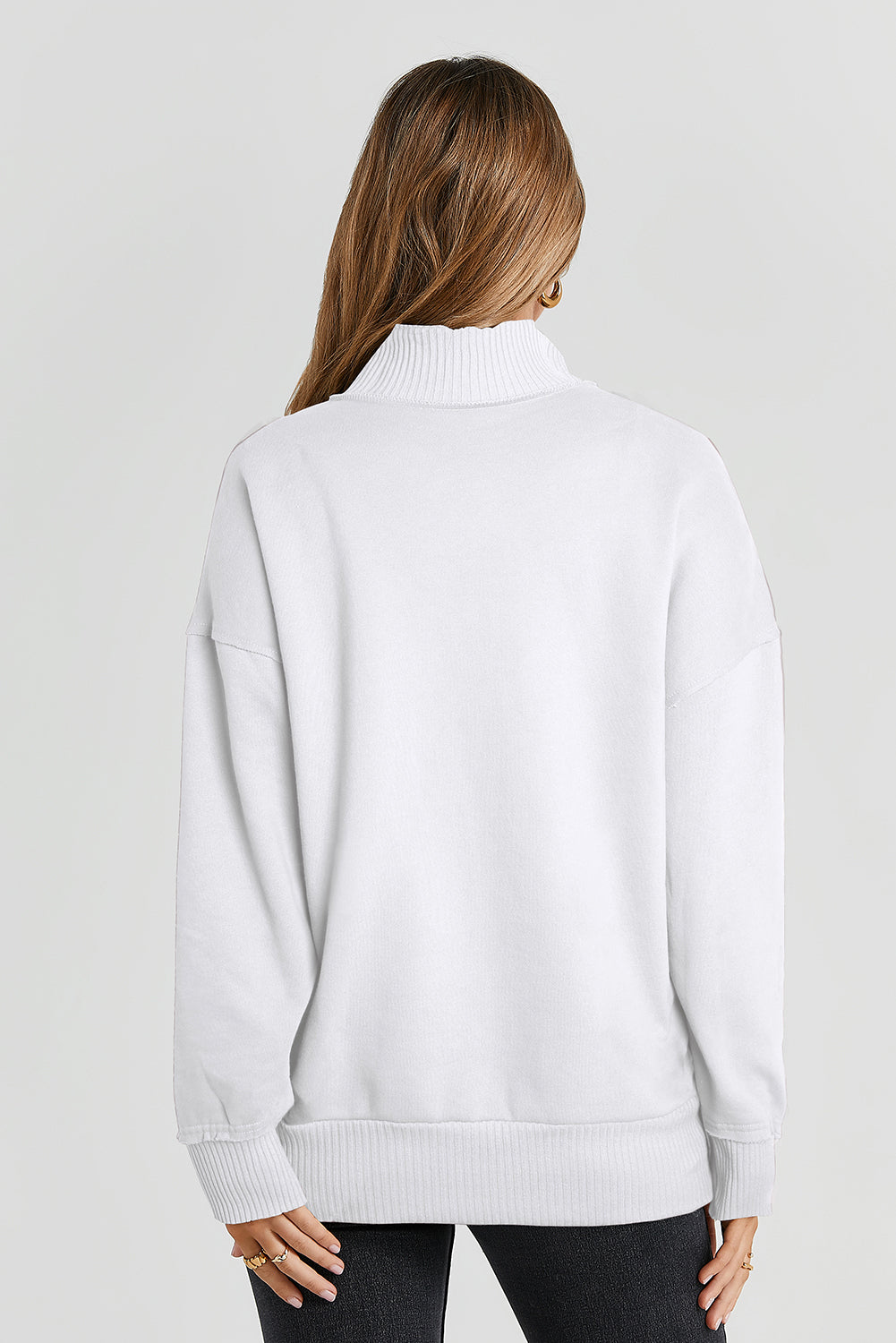 A woman with long hair wearing a White Ribbed Hem Snap Button Neckline Sweatshirt with Pocket is seen from behind, standing against a plain background, embodying a casual look.