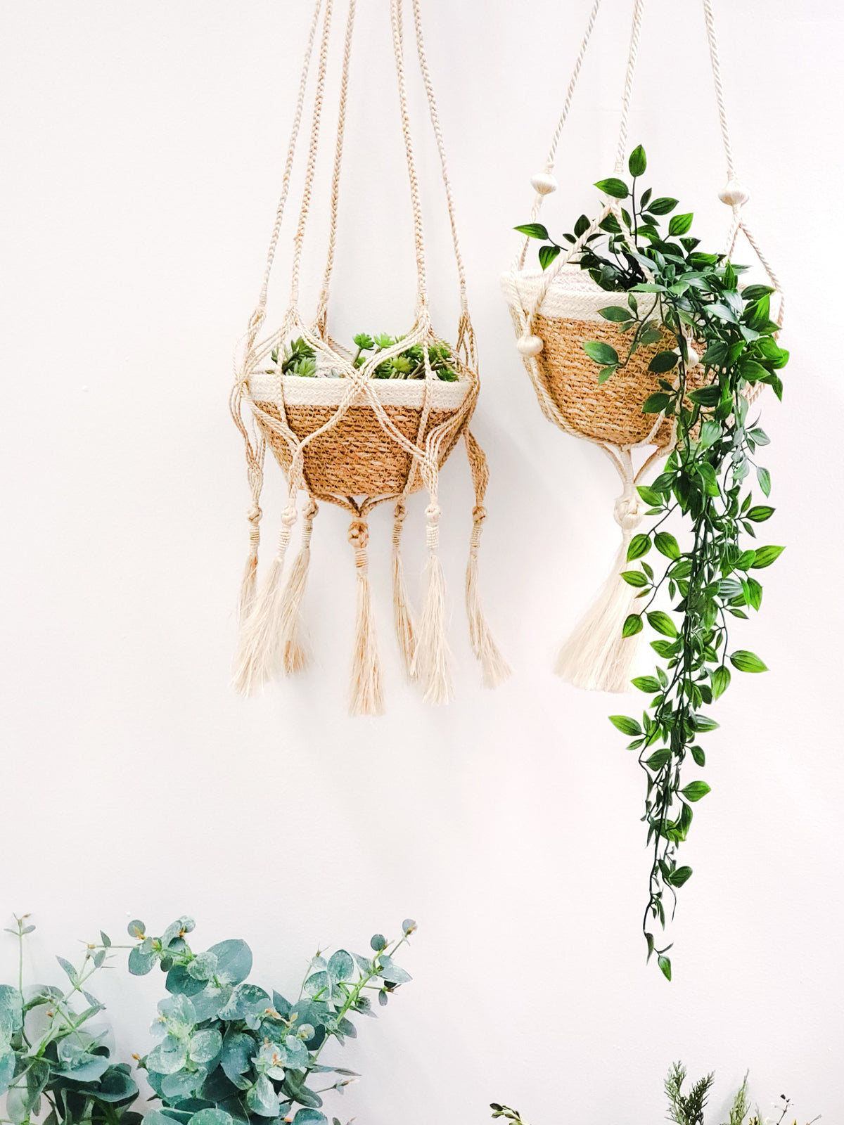 The Plant Hanger - Bitan is a handmade jute hanger crafted by Fair Trade artisans, featuring natural fibers with a striking black base and playful tassels.