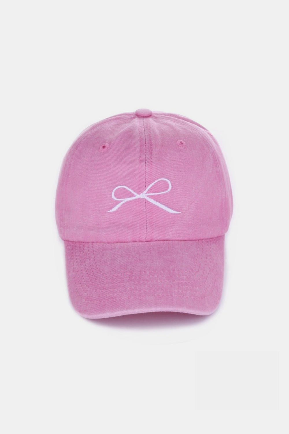 The Zenana Bow Embroidered Washed Cotton Cap features a pink design with a stylish white bow on the front, set against a plain, light background. This chic accessory seamlessly combines elegance and sportiness.