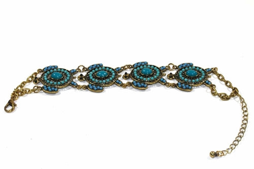 The Colorful Bead Drop Turtle Bracelet is a handmade piece featuring red and orange stones in circular patterns on a gold chain with clasp, boasting an antique style finish that adds timeless elegance to any collection.