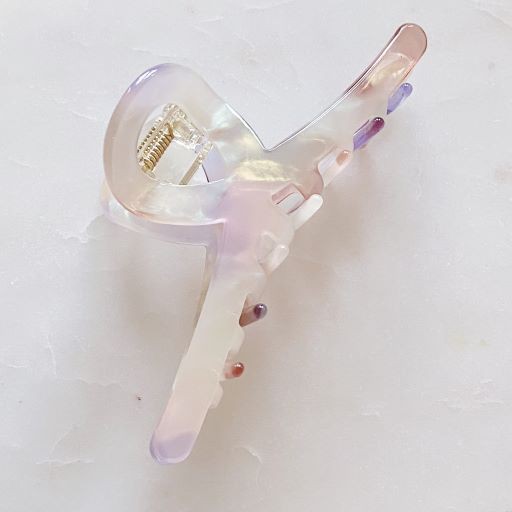 Two different colored Barely There Hair Claws placed on a light-colored surface.