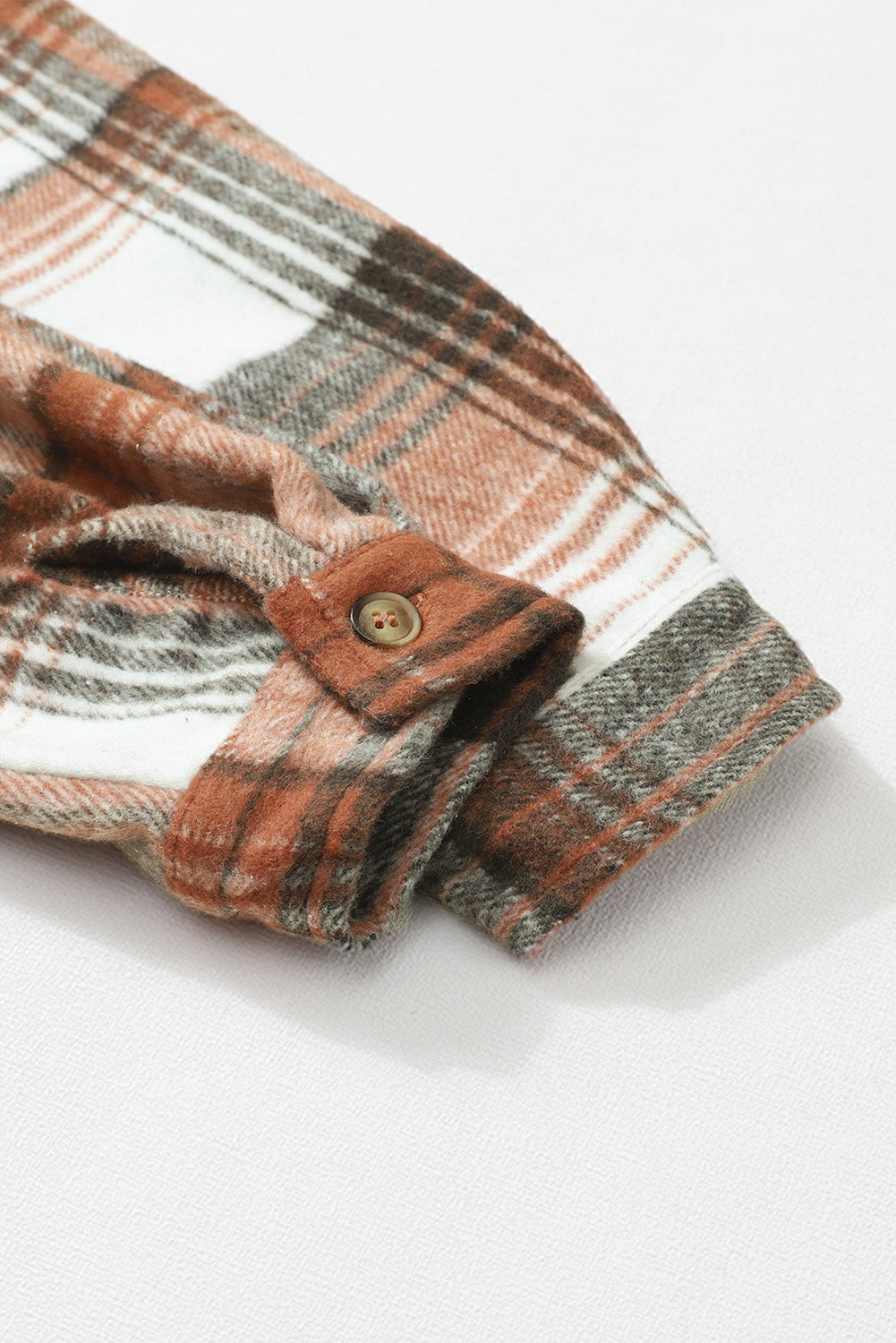 A woman wearing a white top, blue jeans, and the Gold Flame & Grey Plaid Button Up Collared Flannel Shacket smiles while posed outdoors.