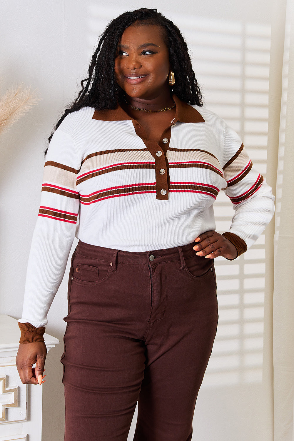 A person wearing the Basic Bae Striped Collared Neck Rib-Knit Top and dark pants is smiling and standing indoors against a light background.