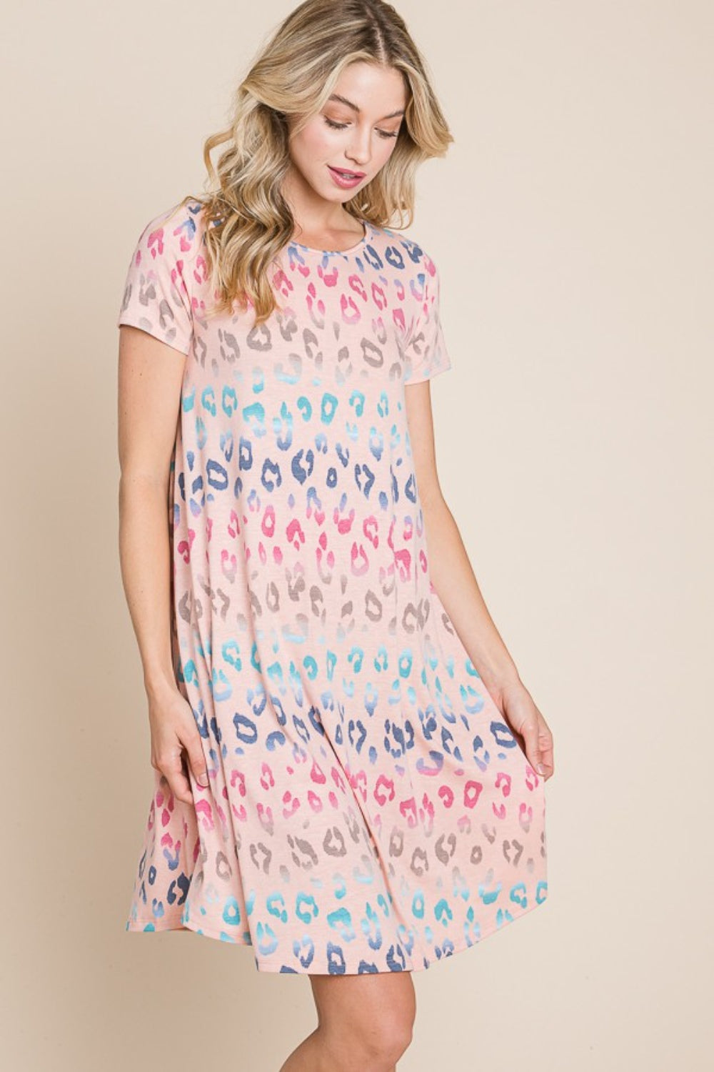 A woman wearing the BOMBOM Leopard Round Neck Short Sleeve Dress and a straw hat poses against a beige background.