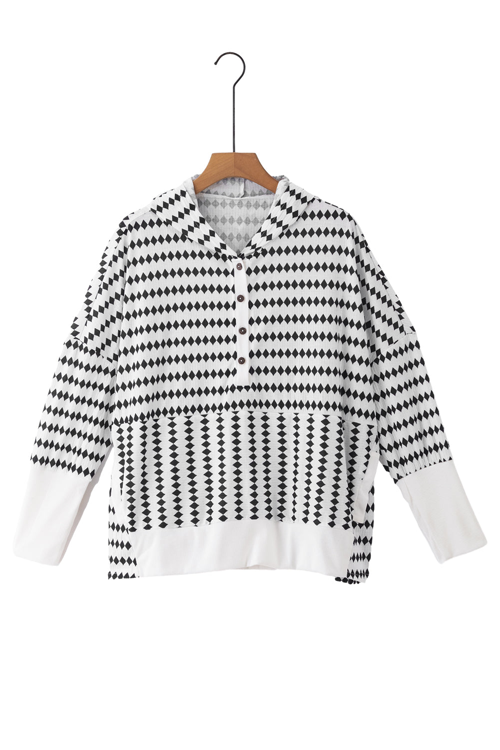 A woman in a Black Stripe Argyle Striped Half Button Oversized Hoodie stands in a room with light green brick walls, a painting of a sailboat, and a fan.