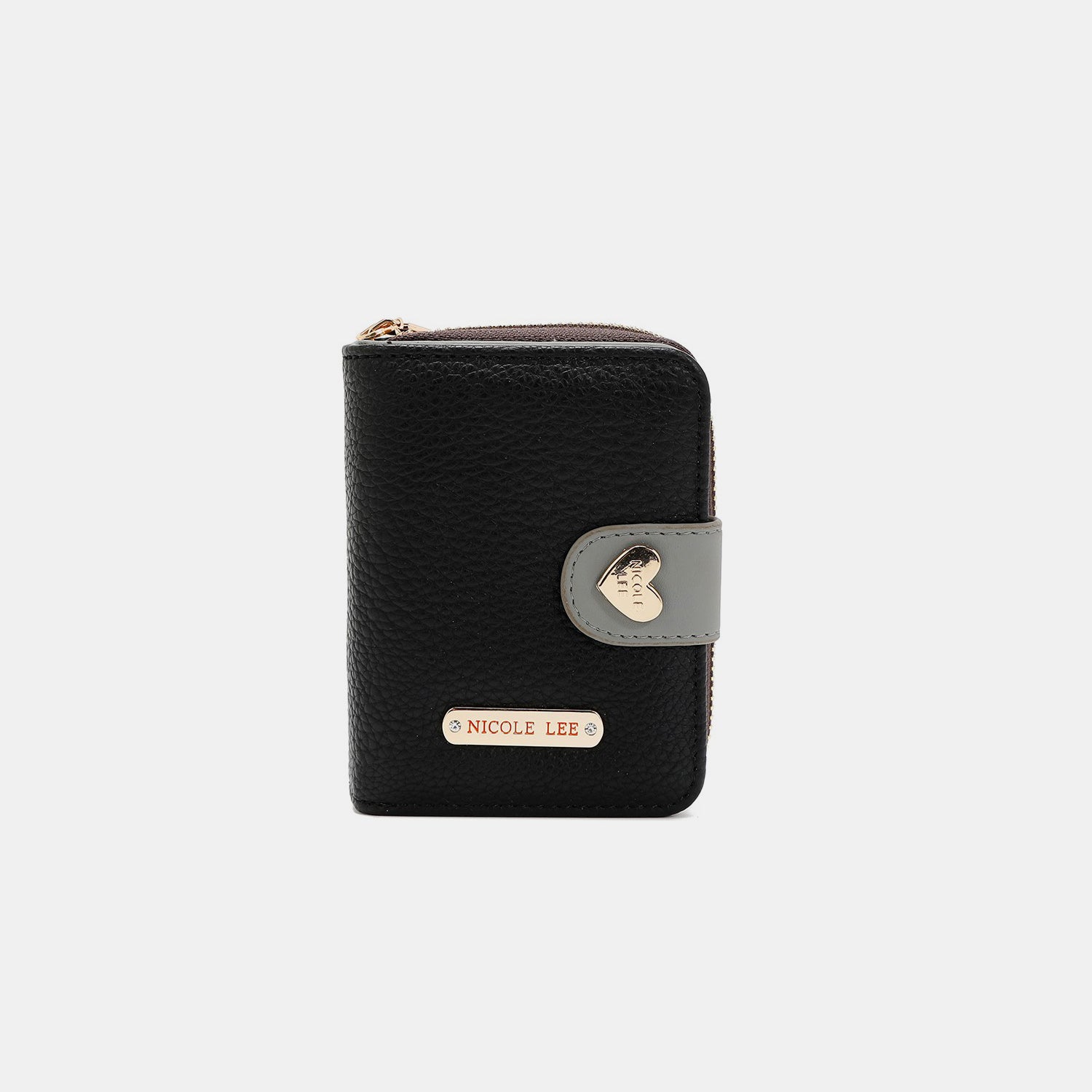 The Nicole Lee USA Solid Heart Bifold Wallet is a small, pink, vegan leather accessory that features a red strap and gold hardware. It includes a zipper and is adorned with a heart-shaped embellishment. The name "Nicole Lee" is prominently displayed on the front.