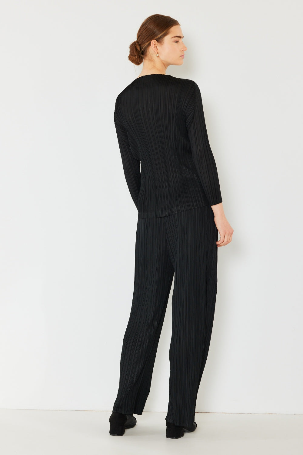 A person wearing the Marina West Swim Pleated Long Sleeve Boatneck Top with matching pants stands against a plain background.