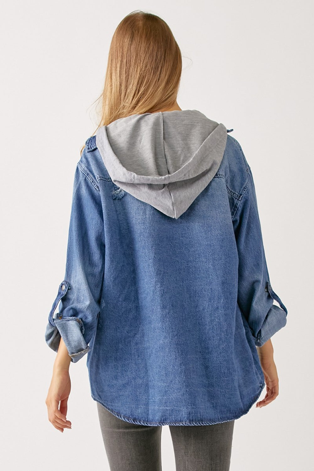 A person with long hair wears a casual oversized grey hooded sweatshirt under a RISEN Zip Up Hooded Denim Shirt.