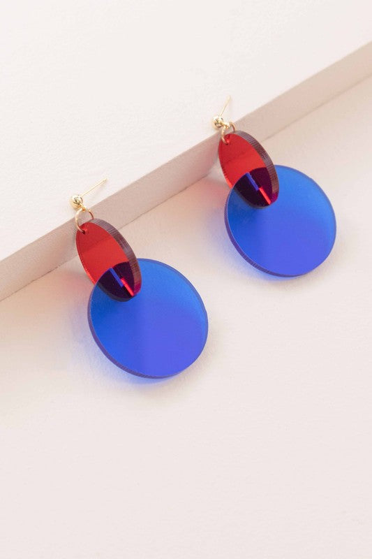 A pair of Clear Color Pop drop earrings with a pop of red accents displayed on a white surface.
