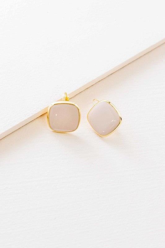 The On the Go Hook Earrings 14K, a pair of square, yellow earrings with 14K gold plate trim, rest on a white surface, bringing a hint of casual style with their elegant yet understated design.
