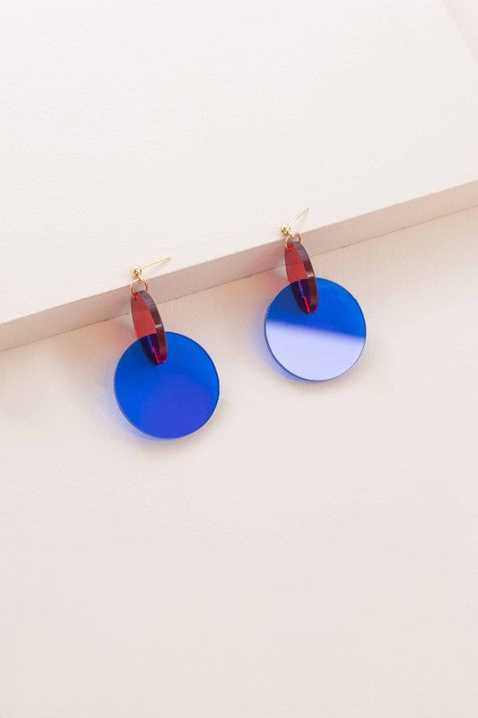 A pair of Clear Color Pop drop earrings with a pop of red accents displayed on a white surface.