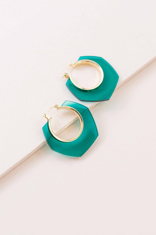 A pair of Angled Clear Hoop Earrings displayed on a white surface.