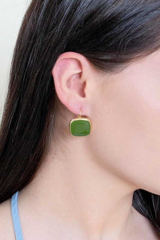 The On the Go Hook Earrings 14K, a pair of square, yellow earrings with 14K gold plate trim, rest on a white surface, bringing a hint of casual style with their elegant yet understated design.