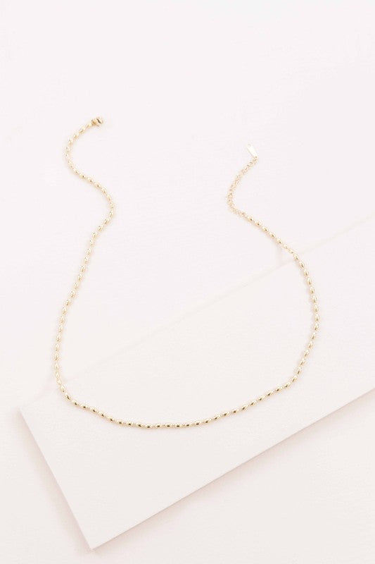 The Gold Beaded Chain Necklace, crafted in 14k gold with intricate details, is elegantly photographed against a white background.