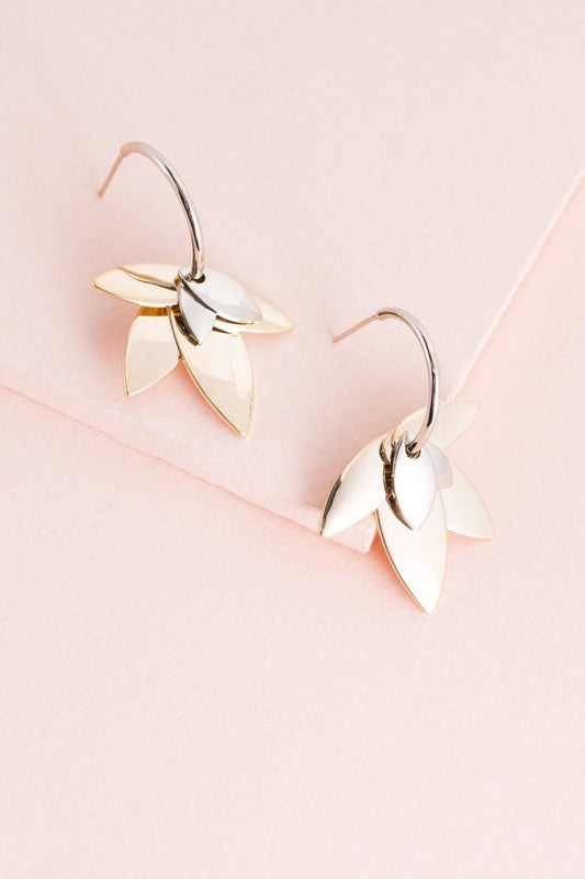 A pair of Two-Tone Lotus Hoop Earrings on a pale pink background.