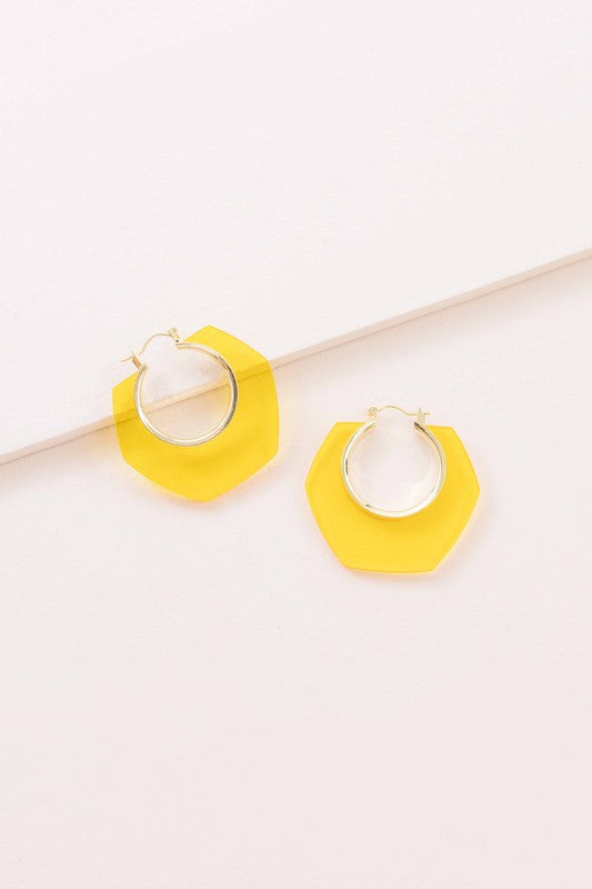 A pair of Angled Clear Hoop Earrings displayed on a white surface.