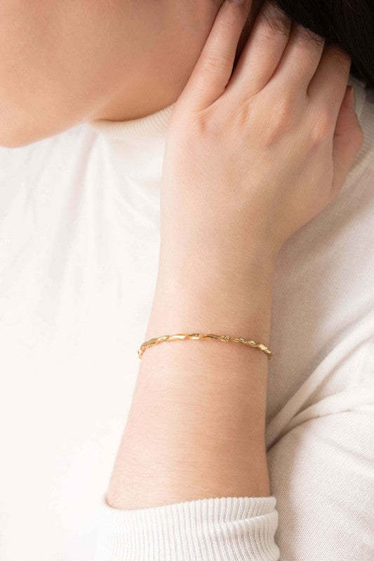 Woman wearing a Gold Twisted Cuff touching her neck.